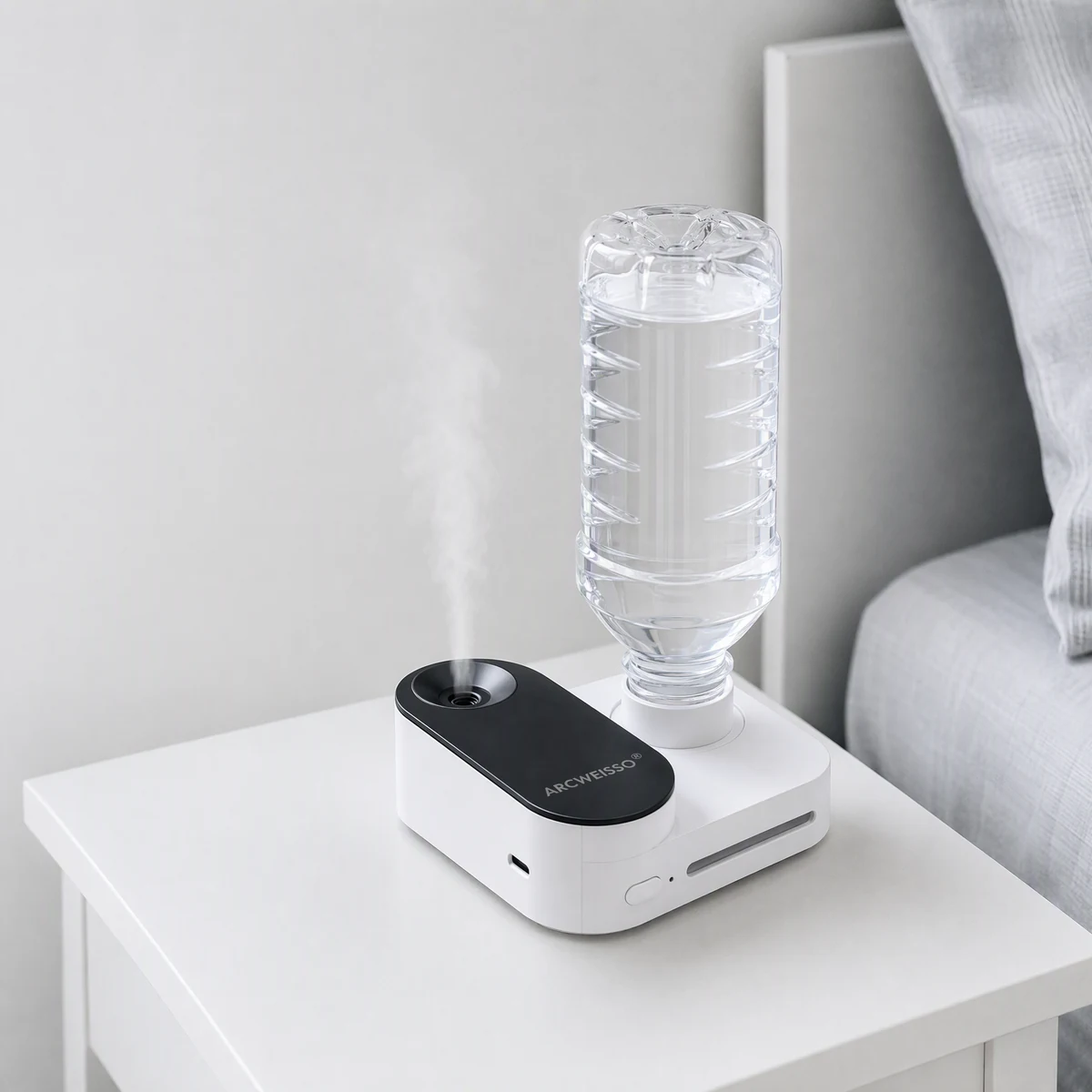 Compact bottle humidifier with an inverted water bottle on a bedside table